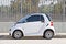 Isolated image of a late model Smart Car parked along the road