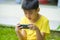 Isolated lifestyle portrait of 7 or 8 years old Asian child focused and concentrated playing with mobile phone outdoors at home