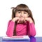 Isolated little girl is sitting at the table with colored pencil