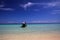 Isolated longtail boat bow on turquoise shallow water under blue sky with few cirrus clouds on tropical island