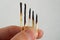 Isolated male hand holding set of burnt matches gradually arranged by stages of their incineration