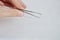 Isolated male hand holding silver tweezers cosmetic pincer used for face cultivation