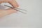 Isolated male hand holding silver tweezers cosmetic pincer used for face cultivation