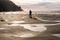 Isolated Male Photographer and Tripod Standing on Ocean Beach