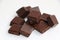 An isolated pile of milk chocolate slab blocks broken up and heaped on a white background