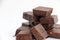 An isolated pile of milk chocolate slab blocks broken up and heaped on a white background