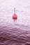 Isolated plastic red bouy on a calm water  - concept image with copy space