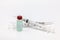 Isolated plastic vaccine bottle with colored liquid and an empty two syringes