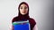 Isolated portrait of Muslim female student holding folders on white background