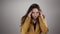 Isolated portrait of young woman suffering from head ache and touching temples by fingers in slowmo