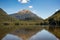 Isolated and remote alpine Lake surrounded by lush dense native forest in Mt Aspiring national park near Glenorchy