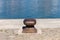 Isolated rusted mooring bollard on the jetty of a commercial dock Italy, Europe