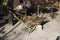 Isolated rusted wheelbarrow with leaves and without wheels