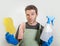 Isolated sad and tired man in domestic cleaning stress holding sponge and detergent soap spray looking overwhelmed and stressed in