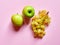 Isolated set of a green apples with a bunch of sweet seedless grapes in studio with millennial pink background