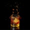 Isolated shot of whiskey with falling ice on black background