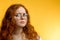 Isolated shot of young funny redhead female stares at camera with shoked expression