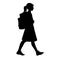 Isolated silhouette of a girl with school backpack going to school