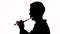 Isolated silhouette of a guy playing the flute. Black and white footage.