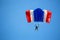 Isolated skydiver in colorful parachute gliding after free fall