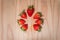 Isolated strawberries in a circle on wood background