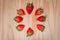 Isolated strawberries in a circle on wood background