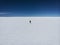 Isolated tourist enjoying endless infinite vastness dreamy landscape of white salt flat lake Salar de Uyuni in Bolivia