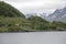 Isolated traditional house on green promontory near Oksfjord, Norway