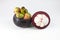 Isolated tropical fruits. One whole mangosteen and another cut i
