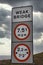 Isolated weak bridge sign in UK with dramatic cloud background