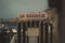 Isolated white sign stands near a picturesque body of water, with boats gently bobbing in the water