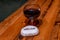 Isolated wine glass filled with red wine on a table with white stone next to it.