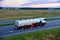 Isothermal Tank truck driving on highway. Oil and Gas Transportation and Logistics. Metal chrome cistern tanker with