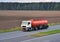 Isothermal Tank truck driving on highway. Oil and Gas Transportation and Logistics. Metal chrome cistern tanker with