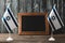 Israel flags with star of david near empty chalkboard