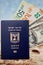 Israeli citizen international passport hundred dollar bills euro and shekels on sand and sea background