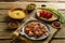 Israeli couscous in spices with sumac and chicken pieces on a linen napkin next to couscous, sumac and vegetables.