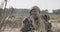 Israeli soldier crawling from cover and looking through binoculars