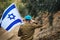 Israeli soldier salutes and holds the flag of Israel in front of him