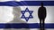 Israeli soldier silhouette standing against national flag, proud army sergeant