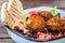 Israeli street food. Falafel salad with hummus, beetroot and vegetables in bowl in a restaurant