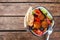 Israeli street food. Falafel salad with hummus, beetroot and vegetables in bowl on wooden background, top view