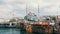 Istanbul, Turkey - June 11, 2019: View of the beautiful white mosque on Eminenu pier. Nearby moored ship Chinese style