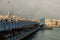 Istanbul, Turkey: people fishing from the Galata bridge in cloudy weather. Downstairs restaurants with fresh fish. Galata tower