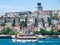Istanbul / Turkey Touristic  cruise ship with passengers at Bosporus strait. Residential buildings at coast in the background