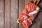 Italian antipasto meat platter with sausage, prosciutto, ham and salami, top view against a wood background