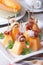 Italian appetizer: melon with ham on skewers vertical