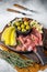 Italian appetizer platter, antipasti snack with Prosciutto ham, Parmesan, Blue cheese, Melon and Olives on wooden board
