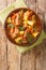 Italian beef stew with potatoes, carrots and celery close-up in a bowl. vertical top view