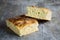 Italian bread of Focaccia Genovese type on a rustic wooden table, sliced in two squared pieces.